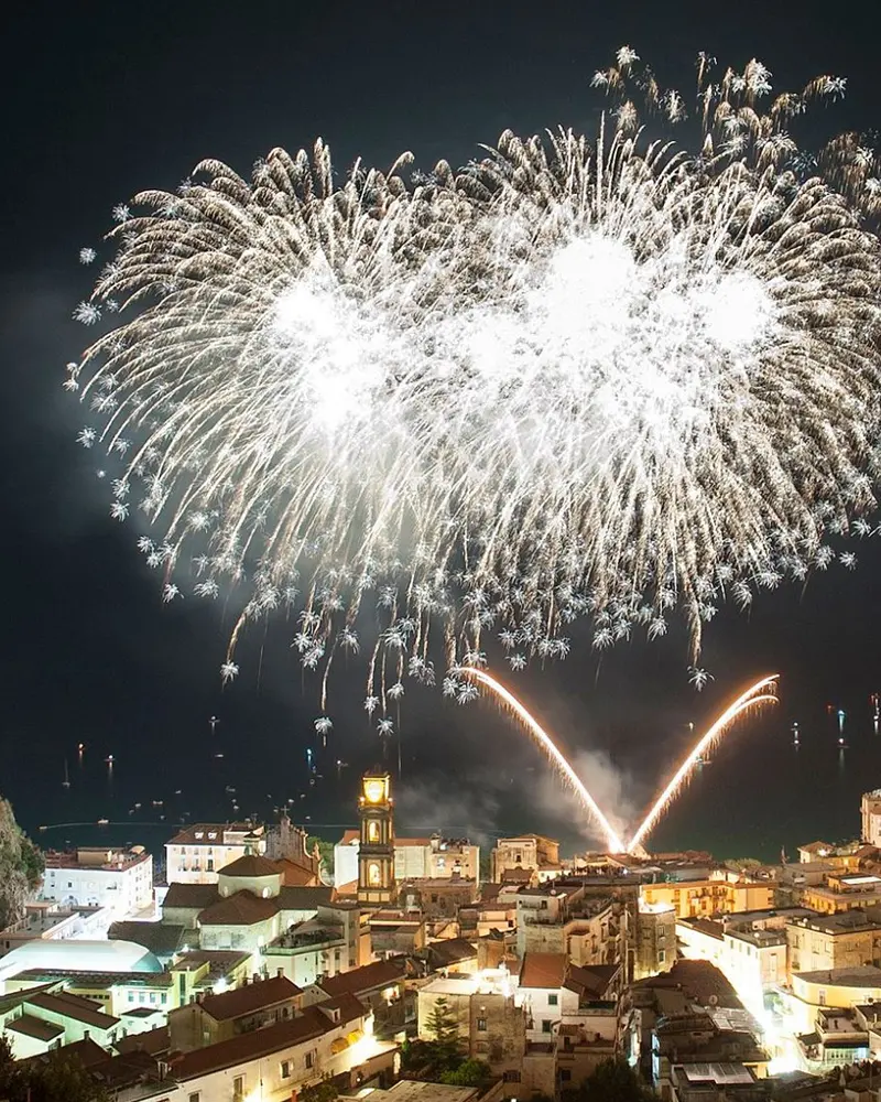 White and gold fireworks above a town on the Amalfi Coast
